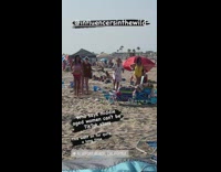 Group of middle aged ladies line dance on sand 
