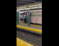 Person hanging onto back of departing subway train