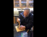 Old guy on counter grating cheese with plastic on