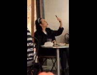 Woman films herself eat food in restaurant