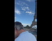 Woman with red heart balloons poses with Eiffel Tower behind