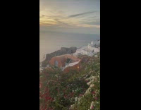 Woman in green sweater poses on top of the house roof