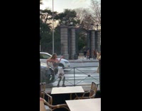 three people take picture of woman on silver car