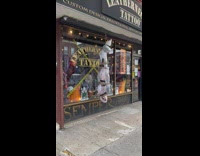 Hanging body decoration in front of tattoo shop