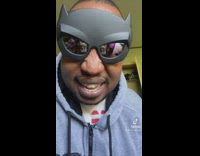 Guy puts on batman glasses while mouthing sound