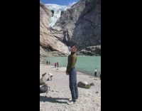 Guy copies blonde ladys pose next to lake 