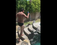 Black speedo guy belly flop pool beer