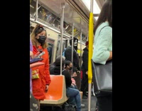 Man with face paint standing on subway