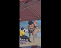 Woman in white bikini see-through shorts twerks at the beach
