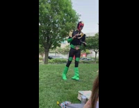 Guy dressed in Judge Dredd costume talks to people at park 