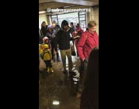 People walking through flooded subway underground tunnel