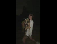 Two guys run and carry goat night