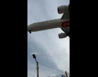 Airplane with the brand Emirates lands close from the filmer