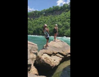 Black backpack girl brown rock blue water