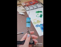 Girl paints beach scene on wine cork 