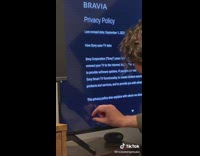 Guy peels plastic off of corner of new TV