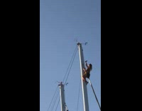 Woman on top of the boat mast takes a selfie