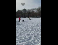 Shirtless guy standing on snow uses kettlebell 