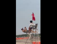 Couple taking pictures on lifeguard chair