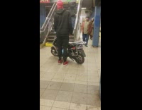 man with small motorcycle train station