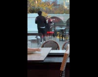 Woman black coat poses outside the restaurant