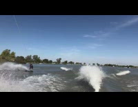 Guy surfs off wave on wakeaboard behind boat and gets wiped out in water