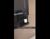 Mouthwash dispenser with small cup in bathroom