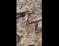 Girl blue bikini guy red cap beach