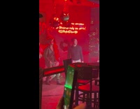 Two men poses and dances in front of the balloons at the party