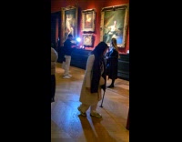 Woman leather coat poses inside the museum