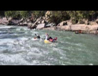 Two people rides the inflatable unicorn boat