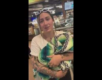Woman carries dog like baby in store