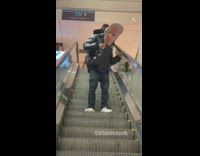 Guy wearing joe biden cutout mask escalator