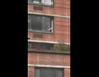 Guy inside apartment window smoking hand movement