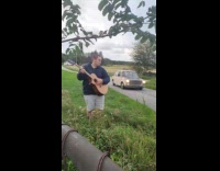 Man plays guitar and stranger waves hand