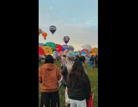 Woman hat jacket look behind hot air balloons