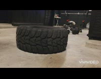 Person smash large tire with candles around