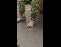 Man in army pants has two bare fake feet