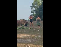 Black bodysuit girl poses by brown cows