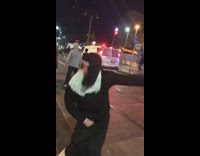 Guy dressed in a nun costume does the Thotiana dance on sidewalk