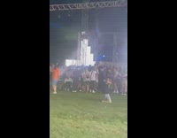 Man kneels on the ground bangs on the beat of the music