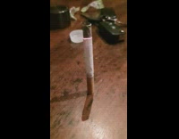 Green lighter empty cigarette burns  wood table