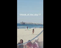 guy in speedo balancing surfboard on head 