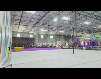 Guy does flips on gray mat in gym