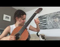 Cat meows and interrupts girl playing guitar 