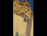 Woman in black dress poses on top of a chapel