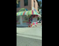 Girl dances by colorful ice cream shop 