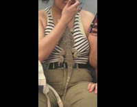 Girl has lizard reptile hanging on her shirt on the subway 
