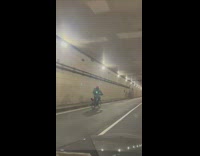 Guy rides bicycle through underpass tunnel 