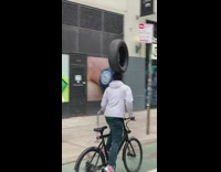 Biker balances tire on head